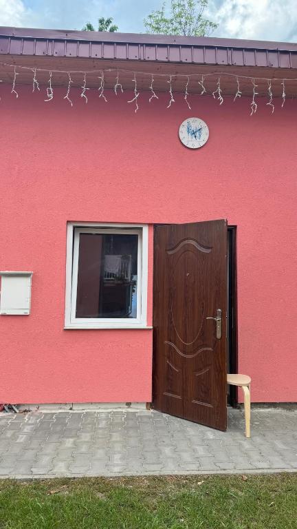 a red building with a wooden door and a window at 布拉格城堡公寓 in Rudná