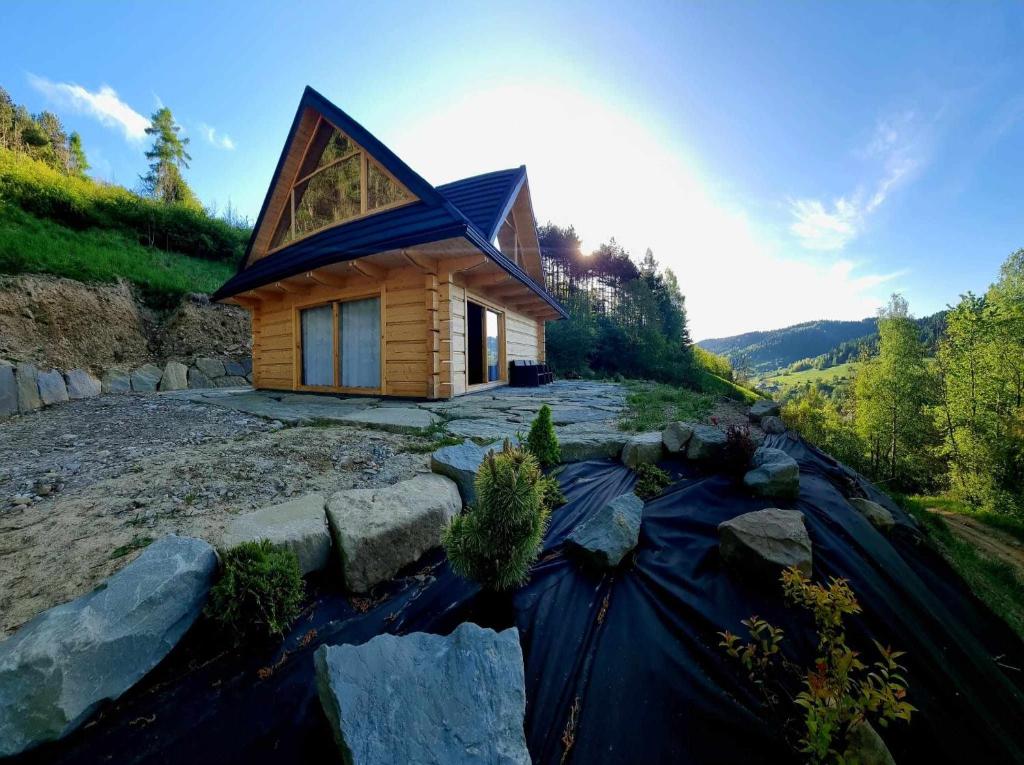 uma casa numa colina com o seu reflexo na água em Domek na zboczu em Ochotnica Górna