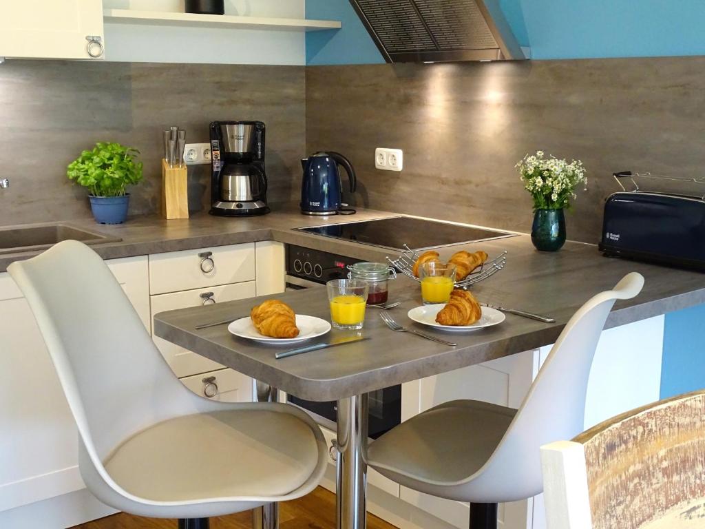a kitchen with a table with bread and glasses of orange juice at Gode Wind Quartiere 2 in Dahme
