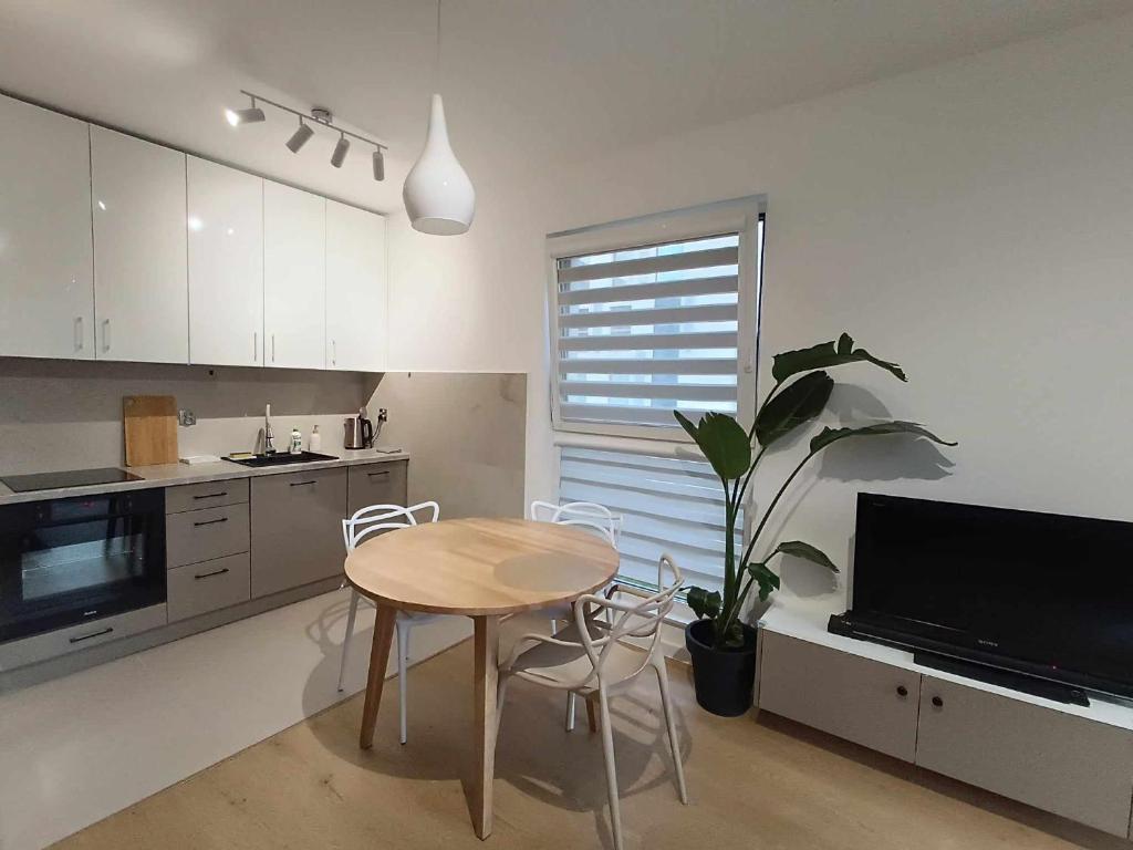 a kitchen with a table and a potted plant at Solaris Bella Apartment- Tauron Arena in Kraków