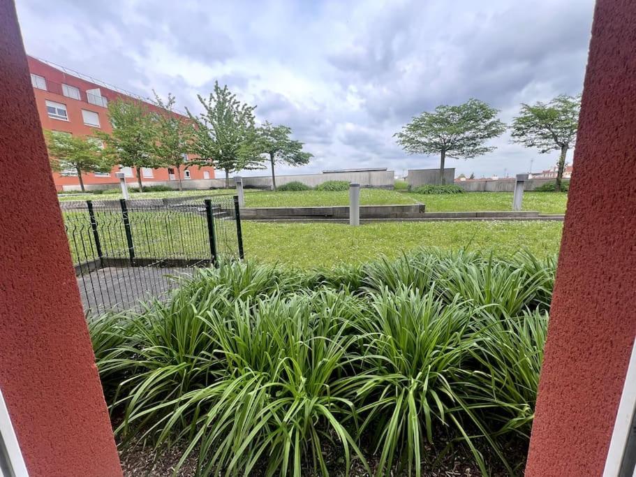 une porte dans un parc avec des plantes dans l'herbe dans l'établissement Ds appartement élégant au pieds du tramway, à Vitry-sur-Seine