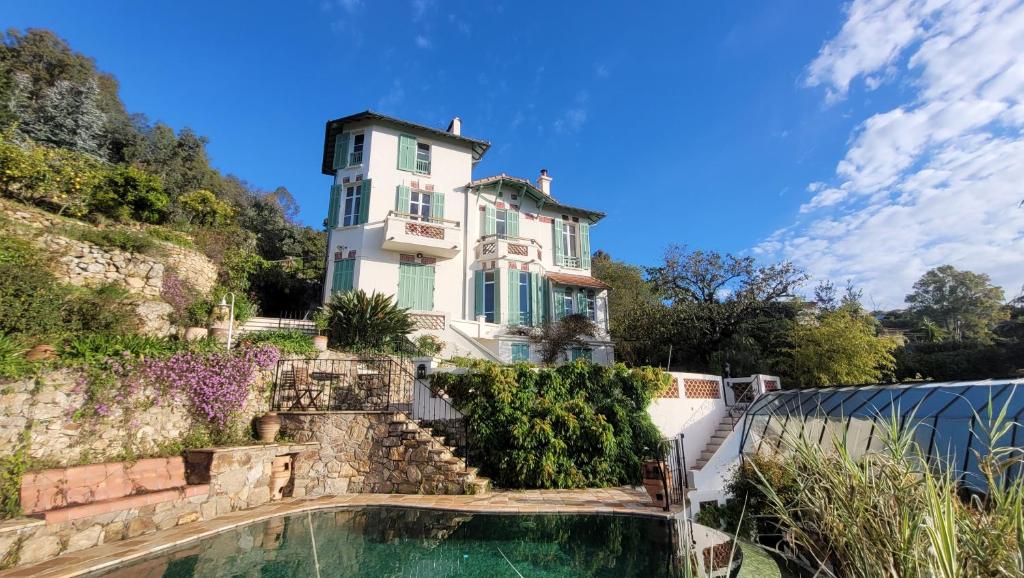 a house on a hill with a swimming pool in front at Villa Ardjoeno in Mandelieu-la-Napoule