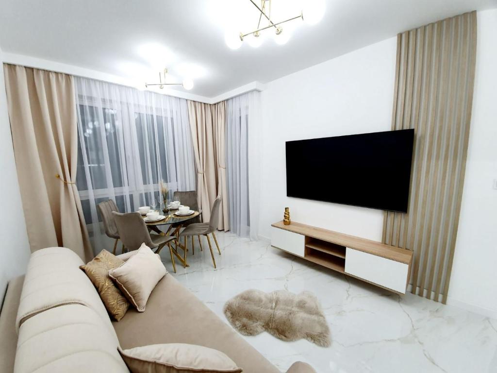 uma sala de estar com um sofá e uma televisão de ecrã plano em Apartament w Centrum em Grodzisk Mazowiecki