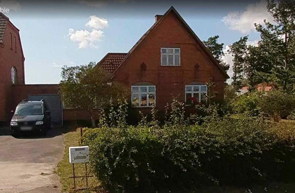 a house with a car parked in front of it at Holiday Home In Poulsker in Neksø