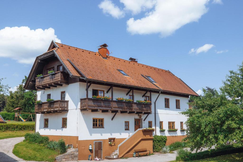 un gran edificio blanco con techo rojo en Bauerborchardt - Urlaub am Bauernhof bei Familie Borchardt en Wernberg