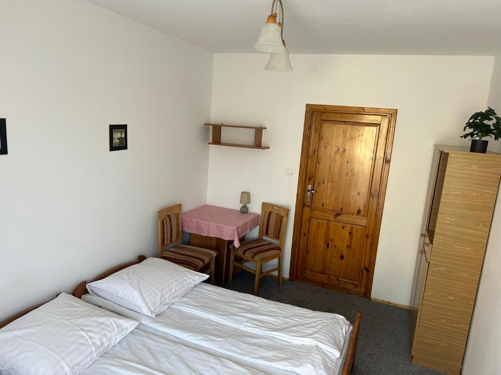 a bedroom with two beds and a table with a pink desk at Anielskie Pokoje in Władysławowo