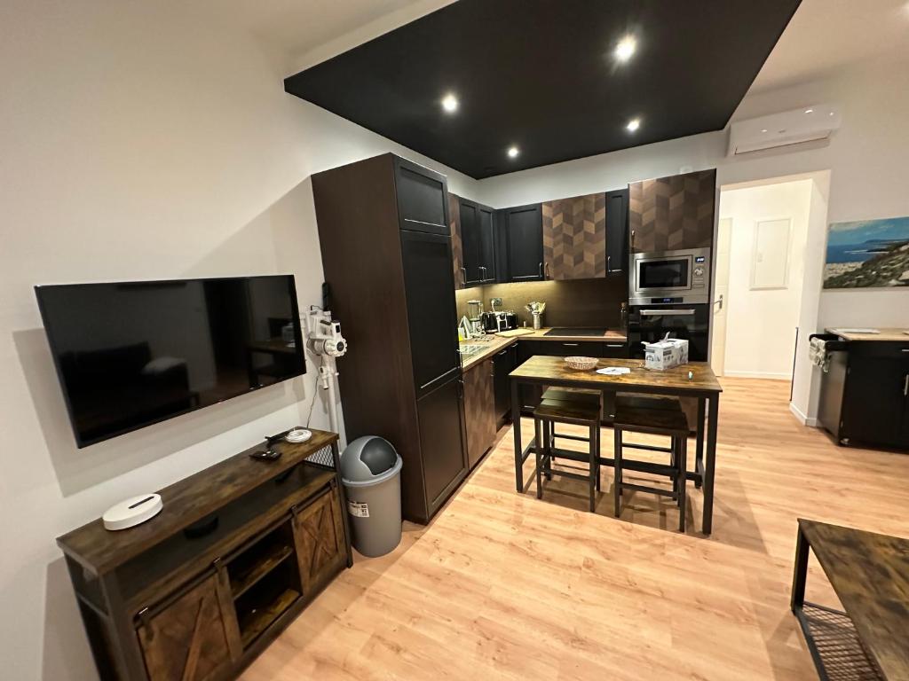 une cuisine avec une table à manger et une grande télévision dans l'établissement Silines, à Hyères