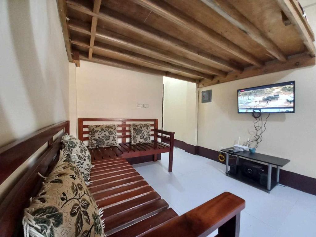 a living room with two benches and a flat screen tv at Condo for Rent - Cagayan de Oro in Cagayan de Oro