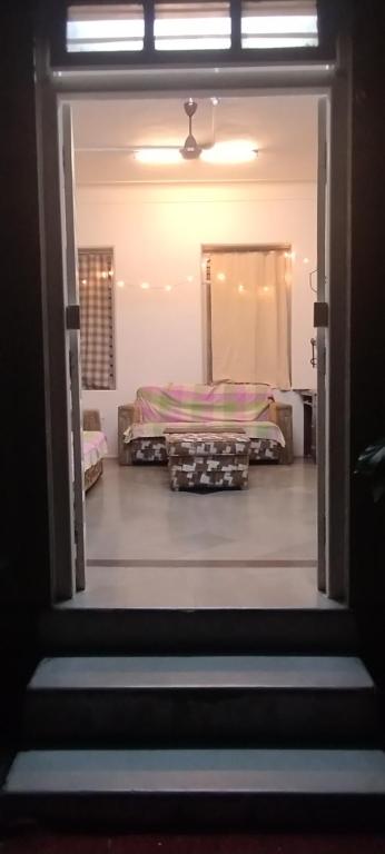 eine Tür, die in ein Schlafzimmer mit einem Bett führt in der Unterkunft Madhav Bhavan Guest House in Pune