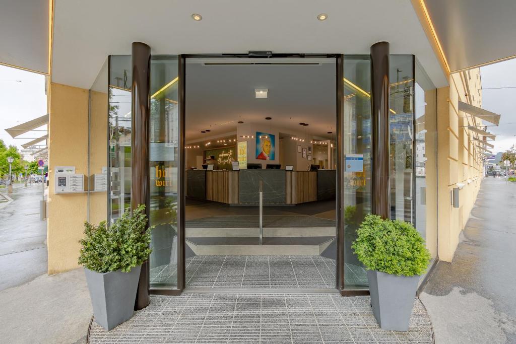 ザルツブルクにあるアルシュタッド ホテル ホフヴィルト ザルツブルクの鉢植えが2つあるショッピングモールの入口