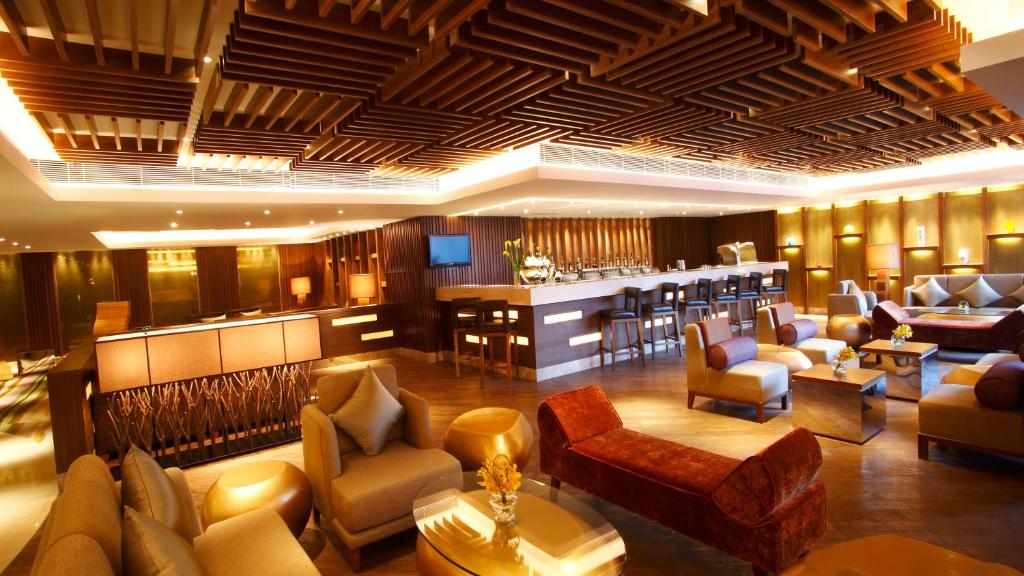 廣州的住宿－廣州中心皇冠假日酒店，酒店大堂设有椅子和酒吧