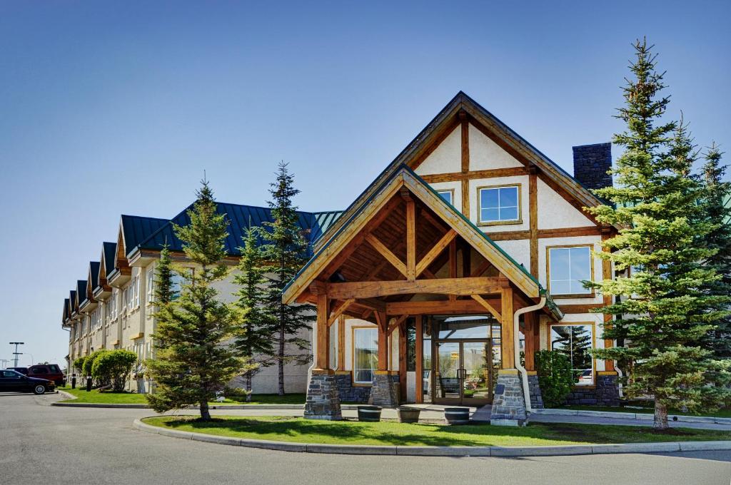 a large house with a gambrel roof at Lakeview Inns & Suites - Okotoks in Okotoks
