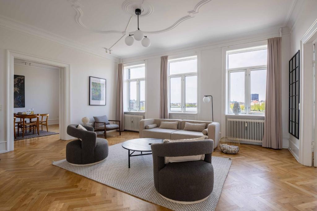 3 Bedroom Flat in Lovely Area في كوبنهاغن: غرفة معيشة مع أريكة وكراسي وطاولة