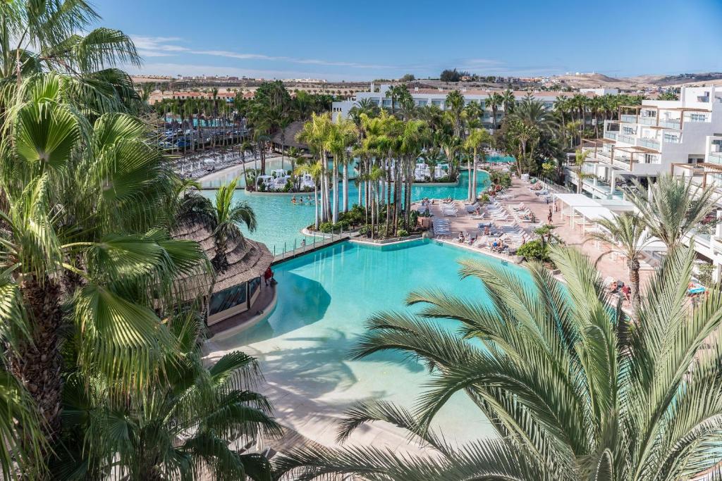 - une vue aérienne sur la piscine du complexe bordée de palmiers dans l'établissement Maspalomas Princess, à Maspalomas