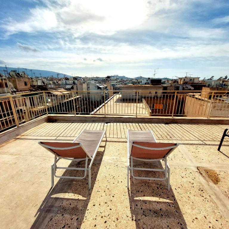 due sedie sedute sopra un tetto di Acropolis View Dream ad Atene