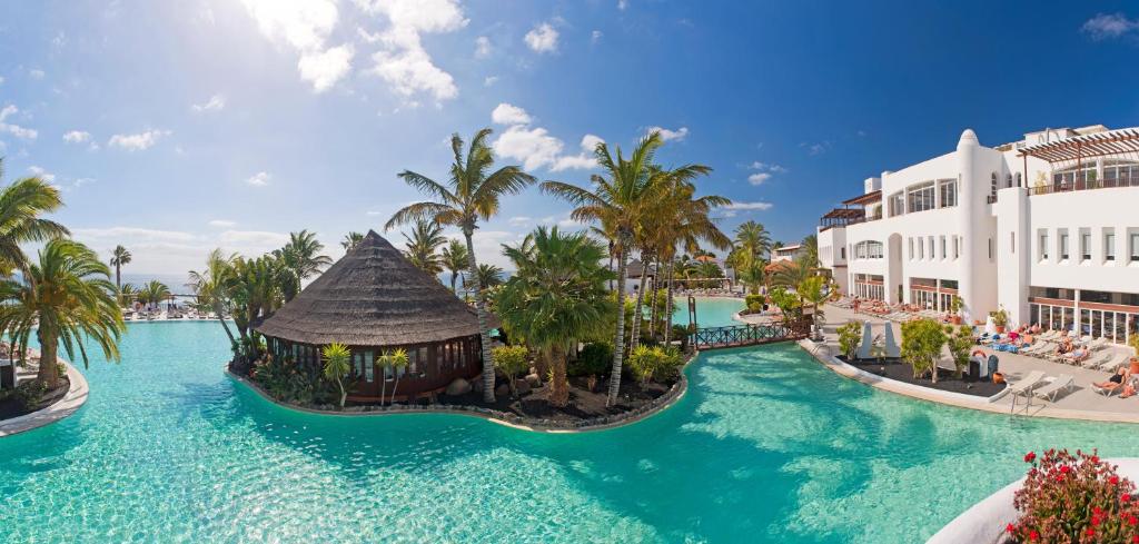 una imagen de una piscina del complejo con palmeras en Club Jandía Princess, en Playa de Jandía