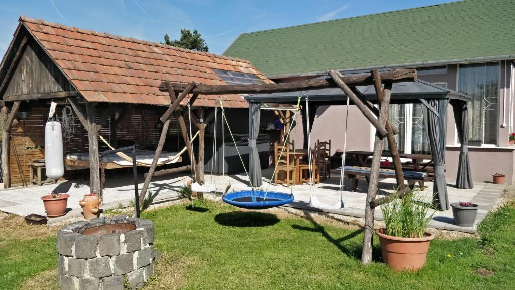 a pavilion with a swing in the backyard of a house at Novákporta vendégház in Lakhegy