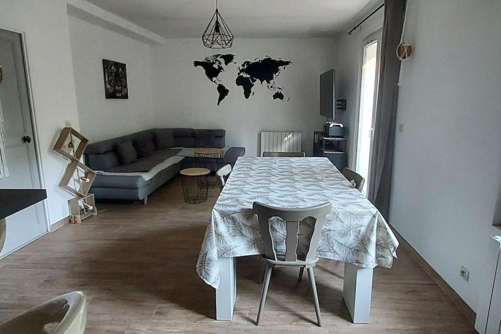 - un salon avec une table et une carte du monde sur le mur dans l'établissement Chez Lucie, à Saint-Maime