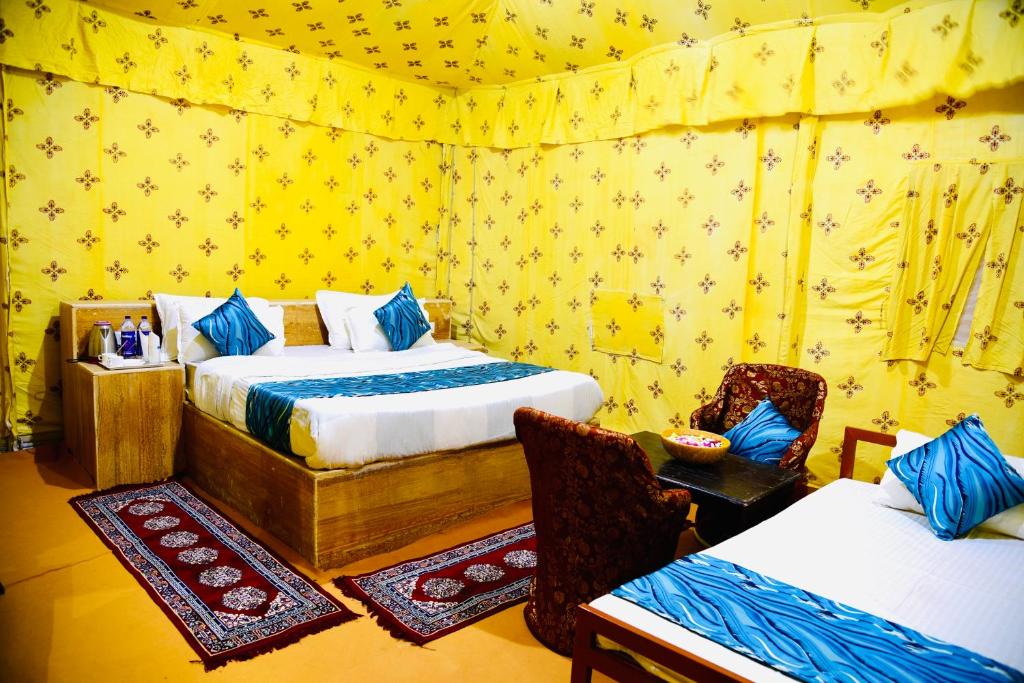 a room with two beds and a table and chairs at Serendipity desert Camp in Thar Desert in Jaisalmer