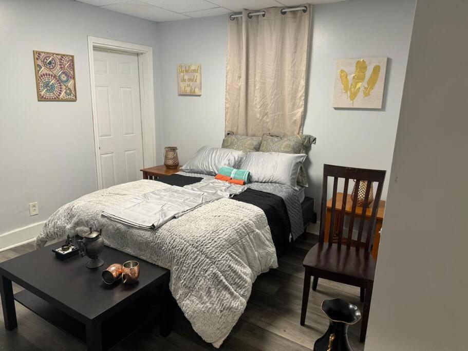 ein Schlafzimmer mit einem Bett, einem Tisch und einem Stuhl in der Unterkunft Wellness Oasis Near Downtown Pittsburgh in Pittsburgh