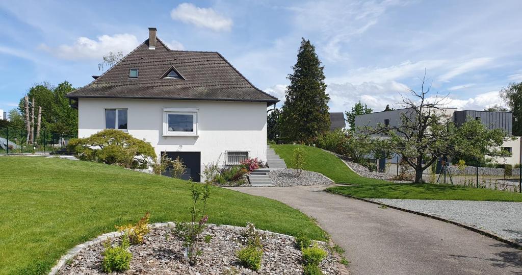 una casa blanca en una colina con entrada en La Maison d'Enfance en Heimsbrunn