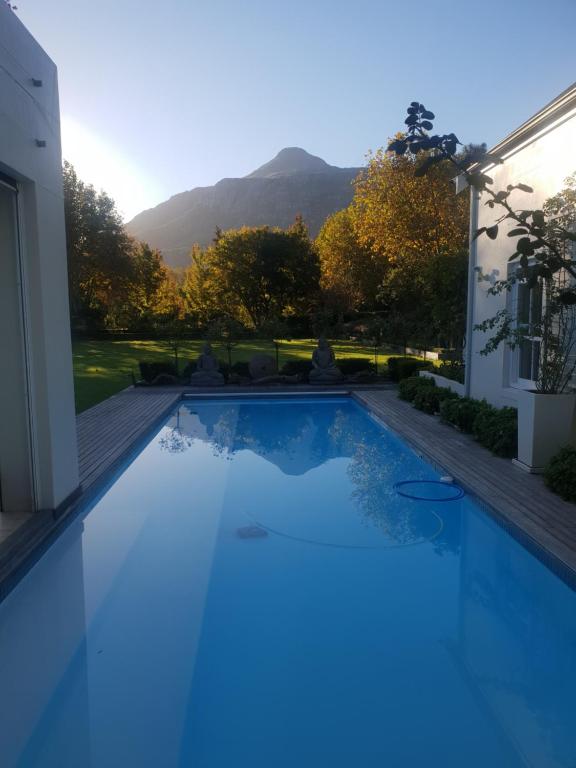 a swimming pool with a mountain in the background at Alzare Villa in Greyton