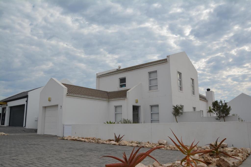 a white house with a white wall at The Whale Tale Villa in St. Helena Bay