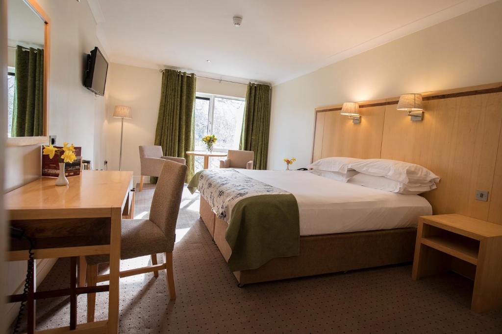 a hotel room with a bed and a desk at Hotel Minella & Leisure Centre in Clonmel