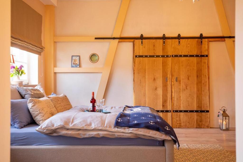 a bed in a room with a barn door at Küstenliebe Gartenpension & Ferienwohnungen in Börgerende-Rethwisch