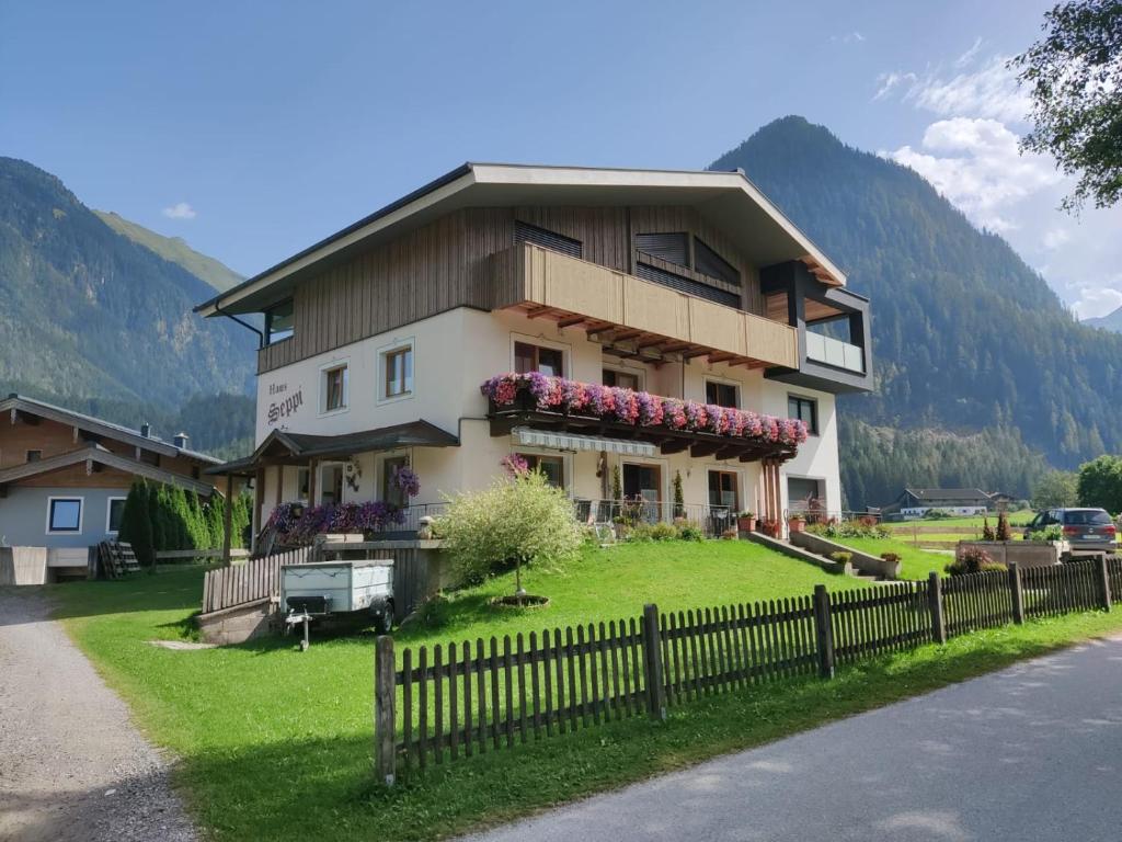 a house on a hill with a fence in front of it at Haus Seppi in Neukirchen am Großvenediger
