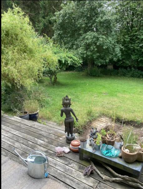 eine Statue einer Person auf einem Deck mit Pflanzen in der Unterkunft Lovely Summer House By The Coast, in Præstø