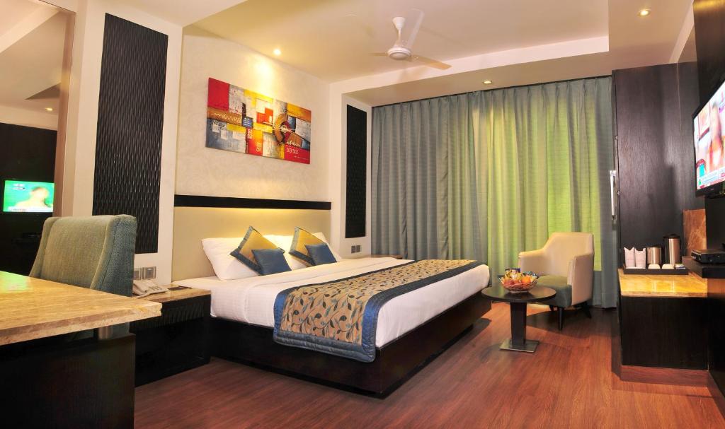 a hotel room with a bed and a desk at Hotel City Star in New Delhi