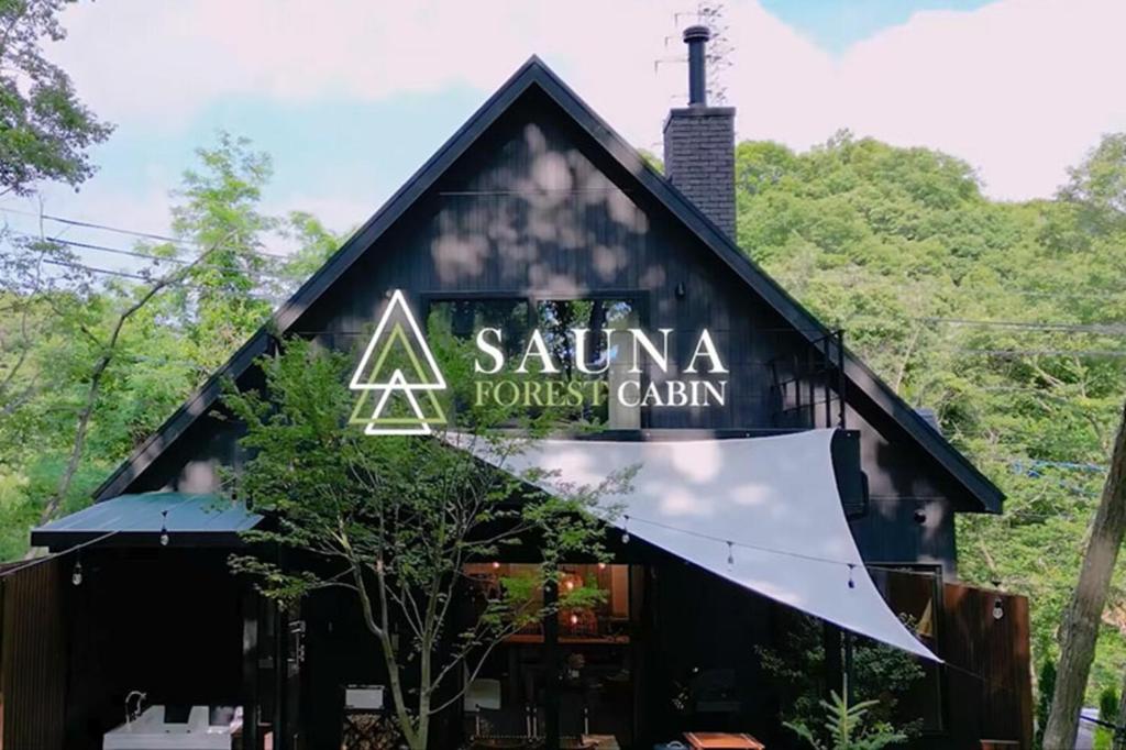 un edificio con un cartello sul lato di SAUNA FOREST CABIN 軽井沢 御代田 B棟 mori-asobi a Oiwake