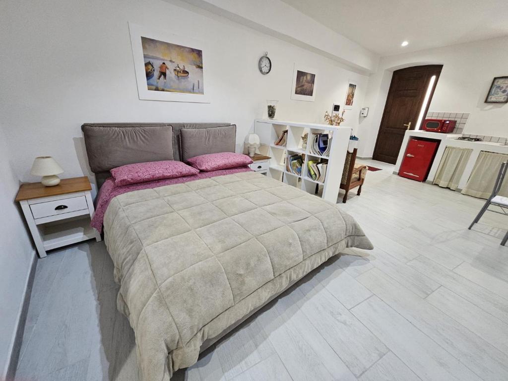 Un dormitorio con una cama grande con almohadas rosas. en Casa Pisani 19, en Iglesias