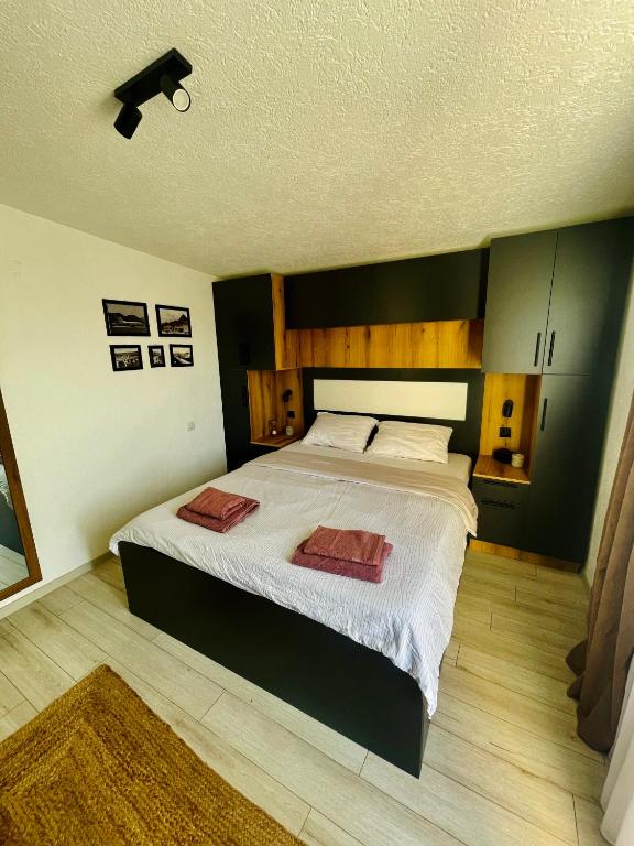 a bedroom with a large bed with two towels on it at Apartments Ivangrad in Berane