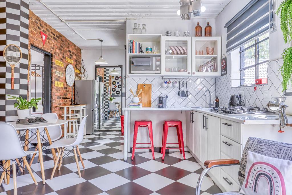 a kitchen with a checkered floor and red stools at The Bedford Manor in Centurion
