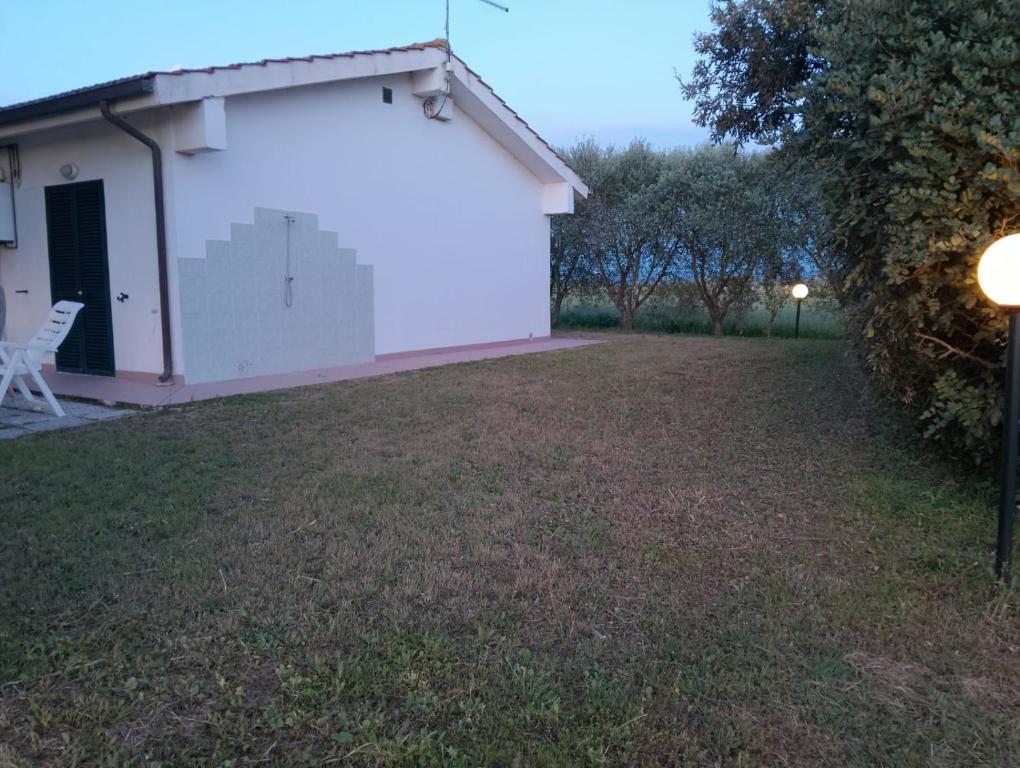 a side view of a white building with a yard at agriturismo I Gelsi Marina di Grosseto in Marina di Grosseto