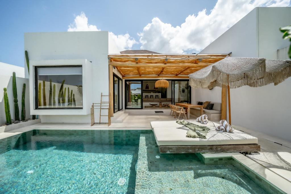 a villa with a swimming pool and a house at Villa Rosado Canggu in Tumbak Bayuh
