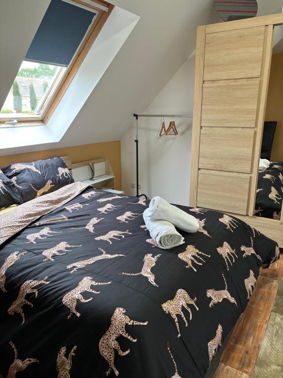 un lit avec une couette noire avec des chevaux dessus dans l'établissement Maison chaleureuse avec barbecue quartier calme, à Voivres-lès-le-Mans