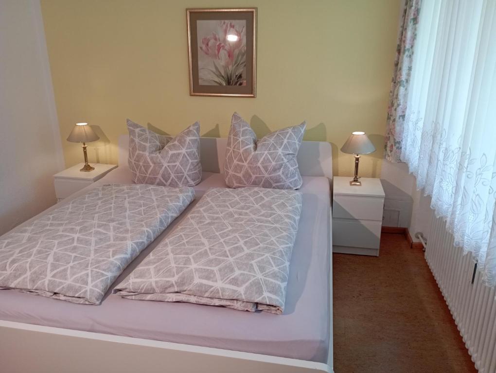 ein Bett in einem Schlafzimmer mit zwei Nachttischen und zwei Lampen in der Unterkunft Exklusive Lage - Wohnung mit schönem Garten - Hämmerle Yellow in Konstanz
