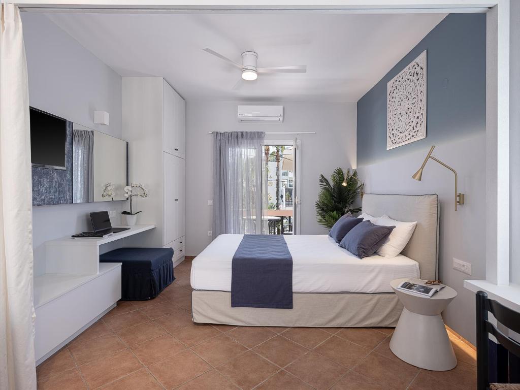 sypialnia z dużym łóżkiem i telewizorem w obiekcie Elena Apartments w mieście Almirida