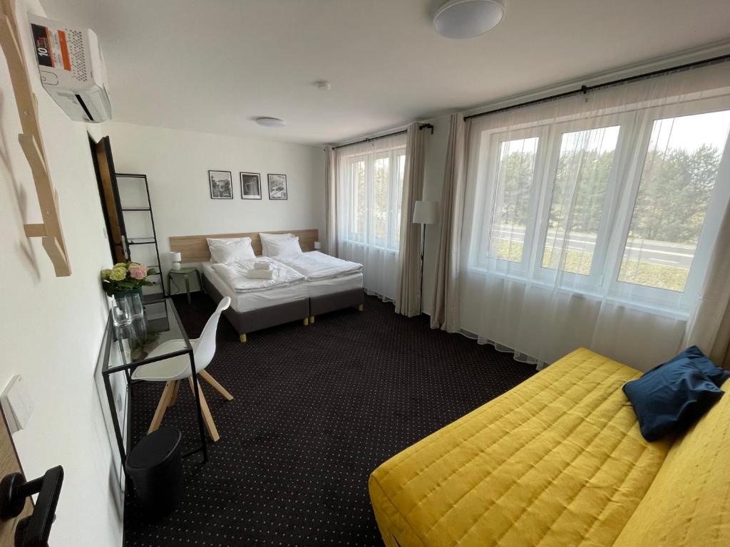 Habitación con 2 camas y 1 cama amarilla. en Penzion Pivovar 66, en Česká Lípa