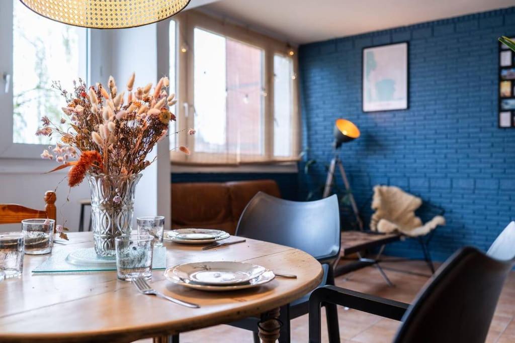 une table de salle à manger avec un vase de fleurs dessus dans l'établissement Agréable Appart face au métro - Parking gratuit, à Lambersart