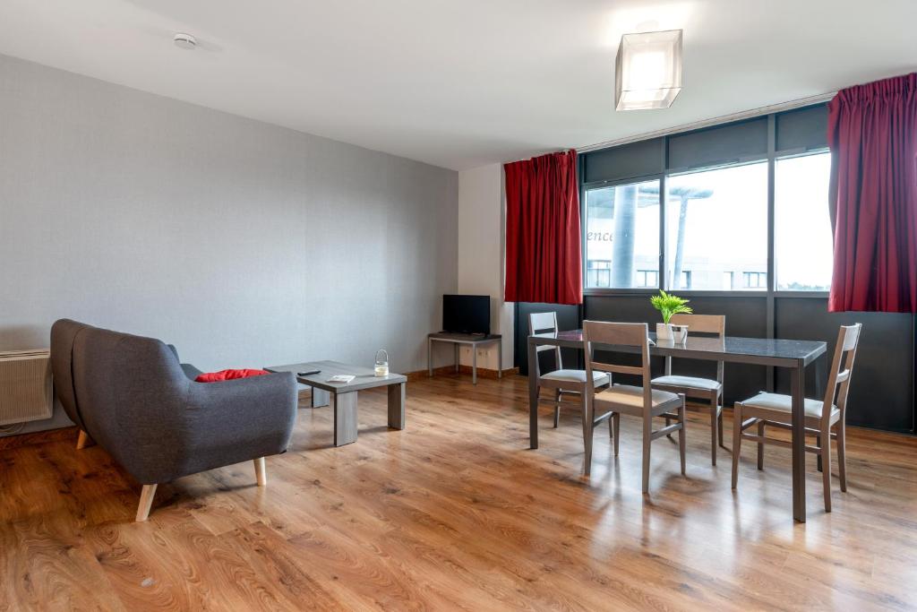 a living room with a dining room table and chairs at Zenitude Hôtel-Résidences Nantes Métropole in Nantes