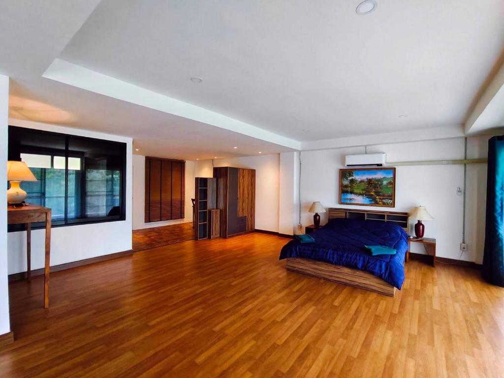 1 dormitorio con 1 cama y suelo de madera en Alpine Mansion, en Ban Huai Sai Nua