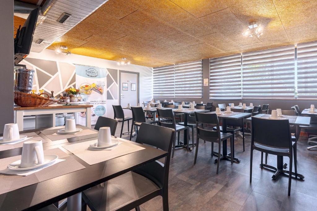 a restaurant with tables and chairs in a room at Zenitude Hôtel-Résidences Nantes Métropole in Nantes