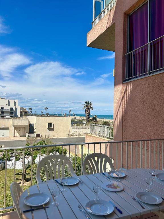 a blue table with chairs on a balcony with the ocean at Superbe appartement vue mer- parking - 6SAR118C in Le Barcarès