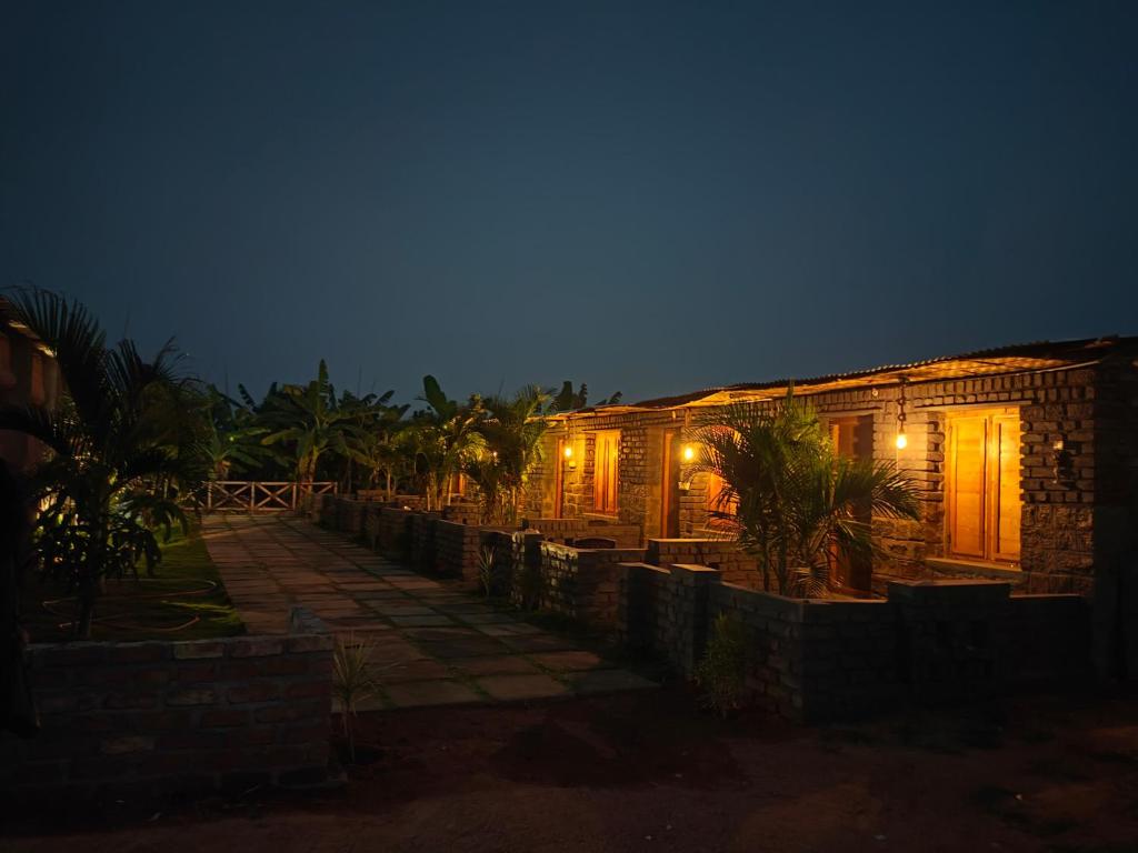 un edificio con luci accese di notte di Taste Of Hampi - Stay @ Nature a Hampi