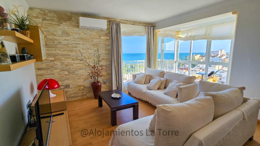 sala de estar con sofá y vistas al océano en Luxury House Relax - Alojamientos La Torre, en Torre del Mar