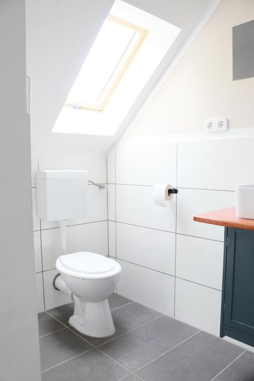 ein Badezimmer mit einem weißen WC und einem Dachfenster in der Unterkunft KS Home in Augsburg
